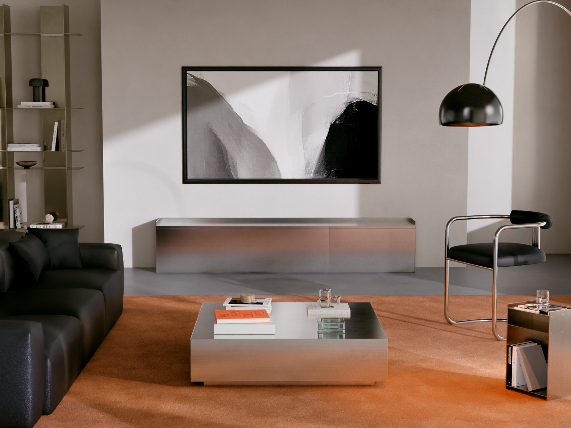 S95H 실버 색상 옵션의 인테리어. 은색 TV 스탠드, 검은색 소파, 주황색 카펫 등 현대적이고 세련된 거실 공간.