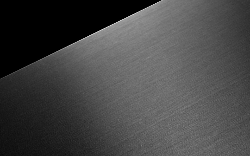 A black metal plate floats against a black background.