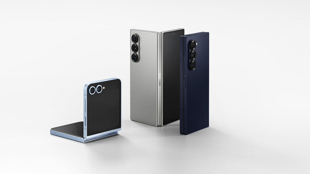 From left, the Galaxy Flip 6 in light blue, open at 90 degrees, and the Galaxy Fold 6 in gray. Next to them is the Galaxy Fold 6 in navy, which is closed.