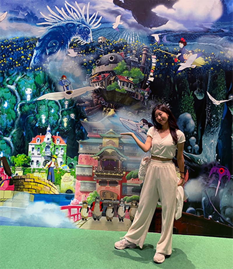 A young Asian woman poses inside the Ghibli Studio exhibition.