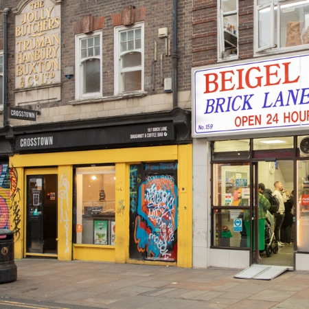 Showcasing the graffiti-adorned Crosstown doughnut shop and the 24-hour 'Beigel Brick Lane,' capturing the unique charm of the city.