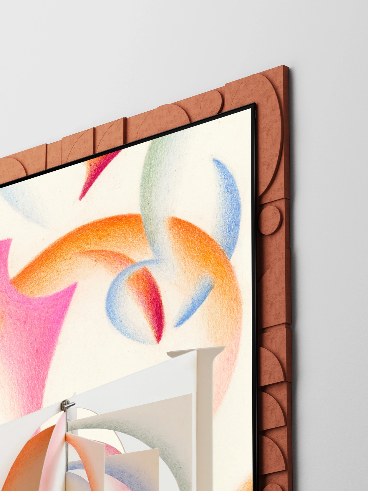 Inside a rust-brown frame patterned with repeating semicircles and circles, three white layered structures suggest The Serif, a slim flat-screen TV. Orange, pink, and pale purple semicircular pieces at the center and soft curves in the background represent time and memories building in layers.