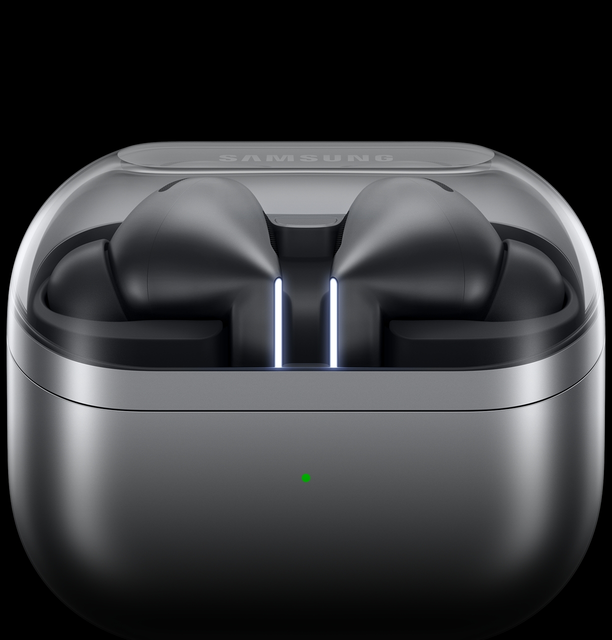 Image of a case “cradle” that is the same dark gray color as the Galaxy Buds3 Pro. The top of the cradle is transparent, allowing you to see the head of the Buzz Three Pro and some of the blade lights. The front of the cradle is illuminated with a small green dot.