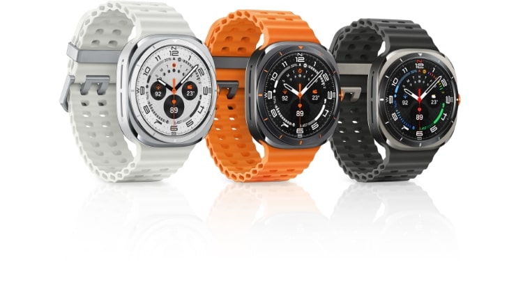 Three Galaxy Watch Ultra locations with marine straps attached. From left to right, white, orange, and dark gray.