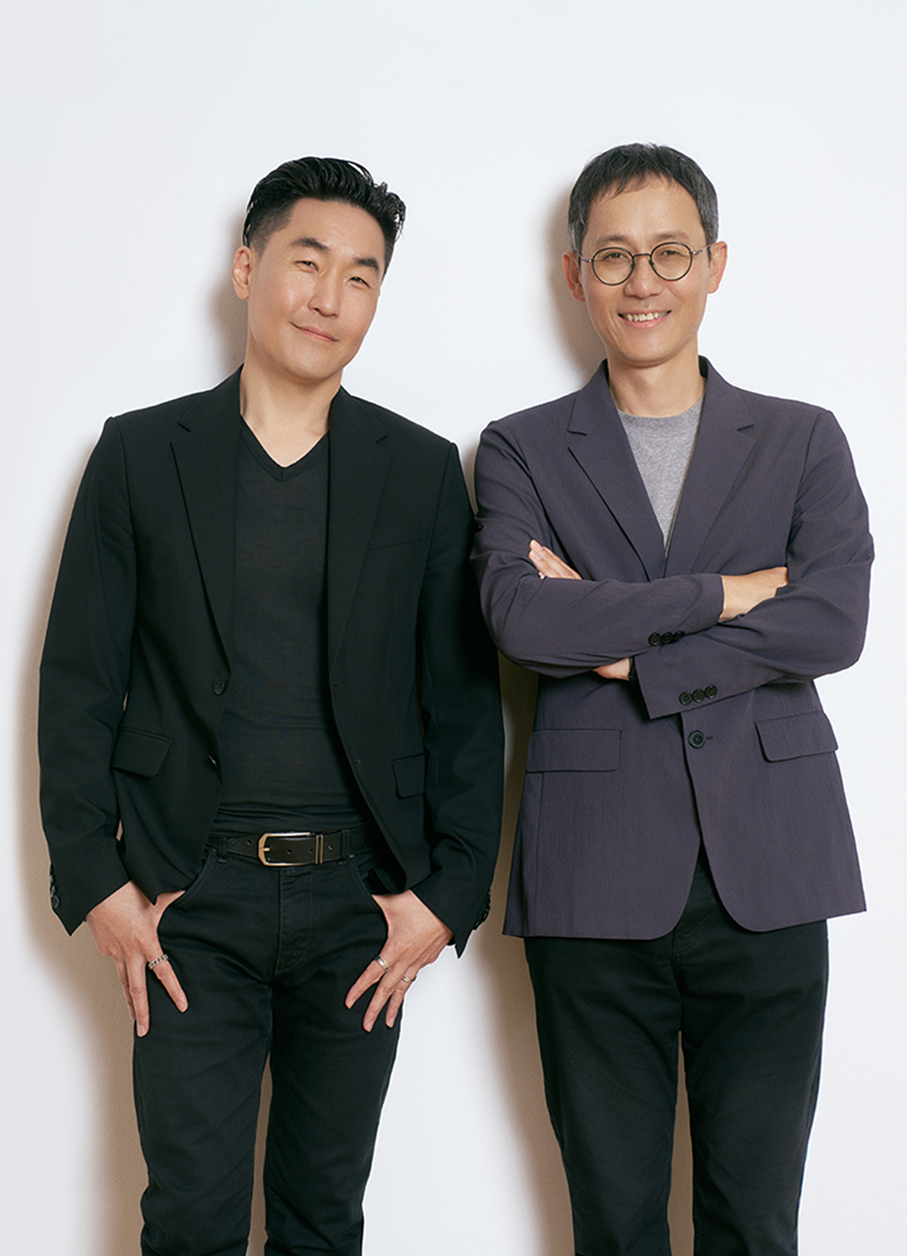 Hubert Lee, Head of Design Team in the MX Division, wearing a black jacket, and Heecheol Yang, UX Team Lead in the MX Division, wearing a gray jacket and glasses, standing side by side and smiling.