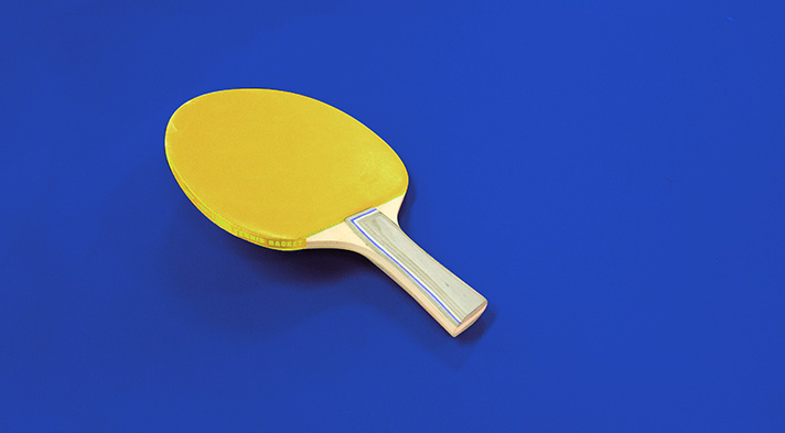 This is an image of yellow S Pen take a picture of a yellow table tennis paddle. 
