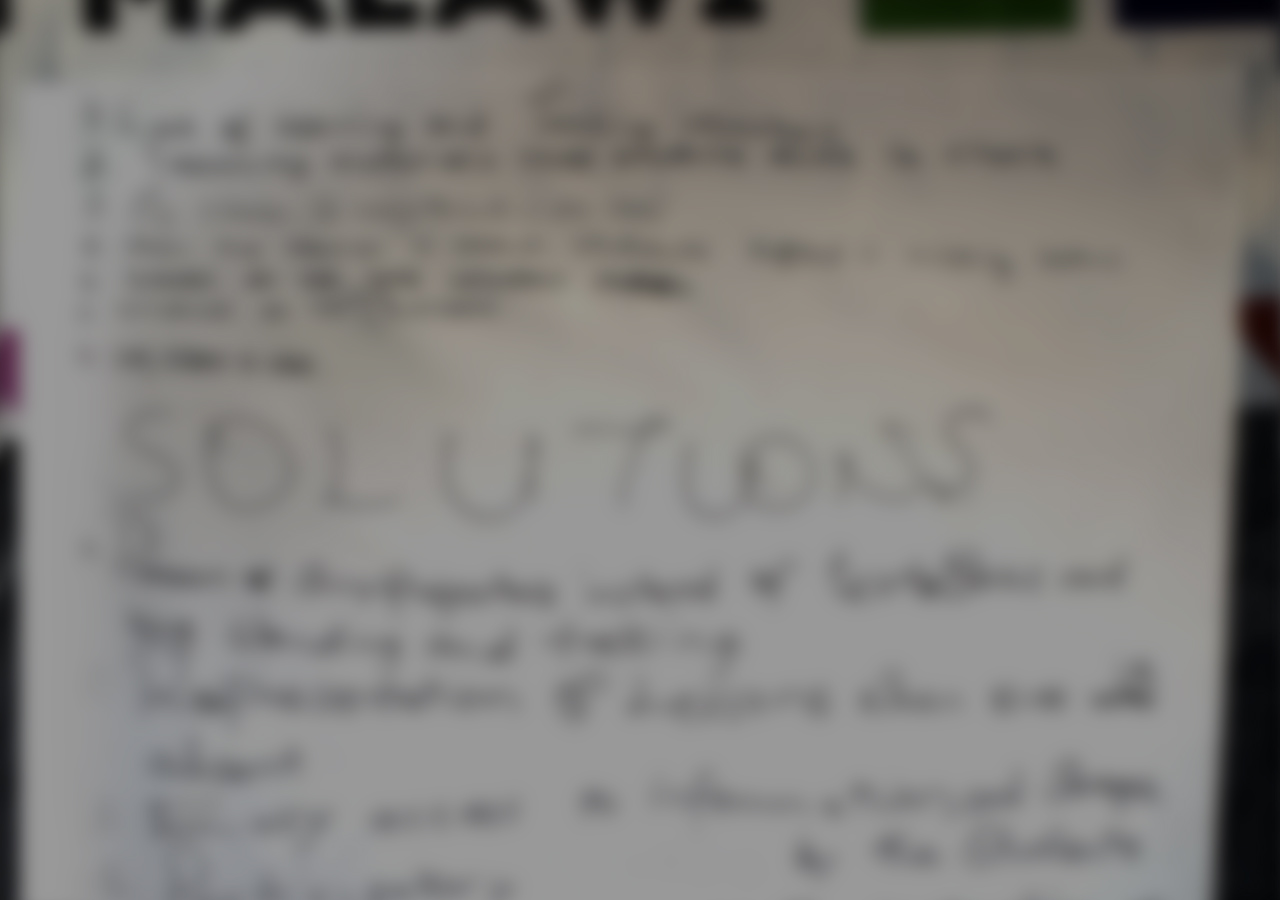 An blurry image shows writing on a notepad. Three interlocking diamonds display the text “Idea – The ideas of Togo Martine”, “Entertainment – Martin’s Theater”, “Education – Shiny