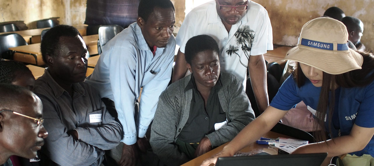 An animation fades-in to show an image of African teachers watching a Samsung employee during a demonstration.