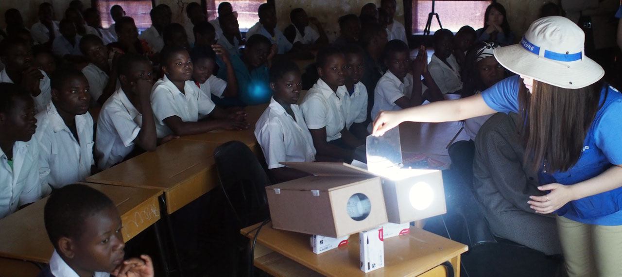 An animation fades-in to show an image of happy children as a Samsung employee controls the Shiny Projector