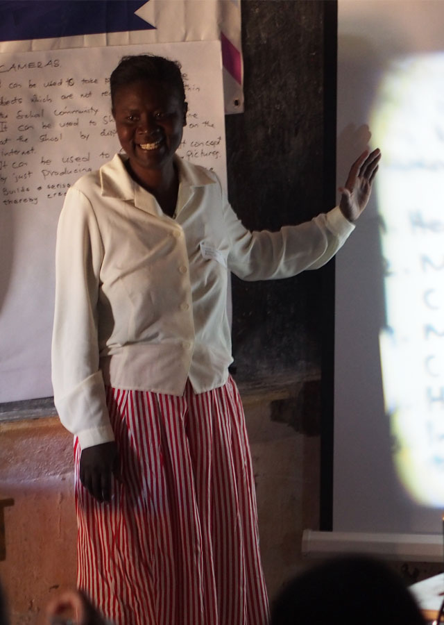 An image shows an African teacher giving a lecture