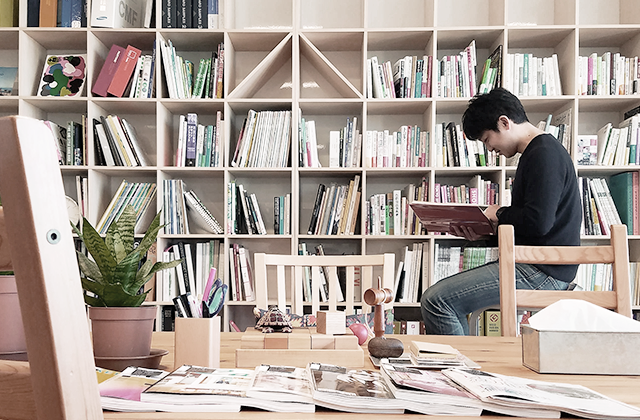 An image shows an SDJ staff member reading a book