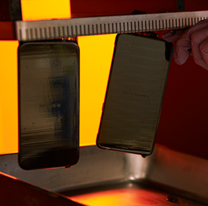 A mobile phone model is being separated from a 3D printer.
