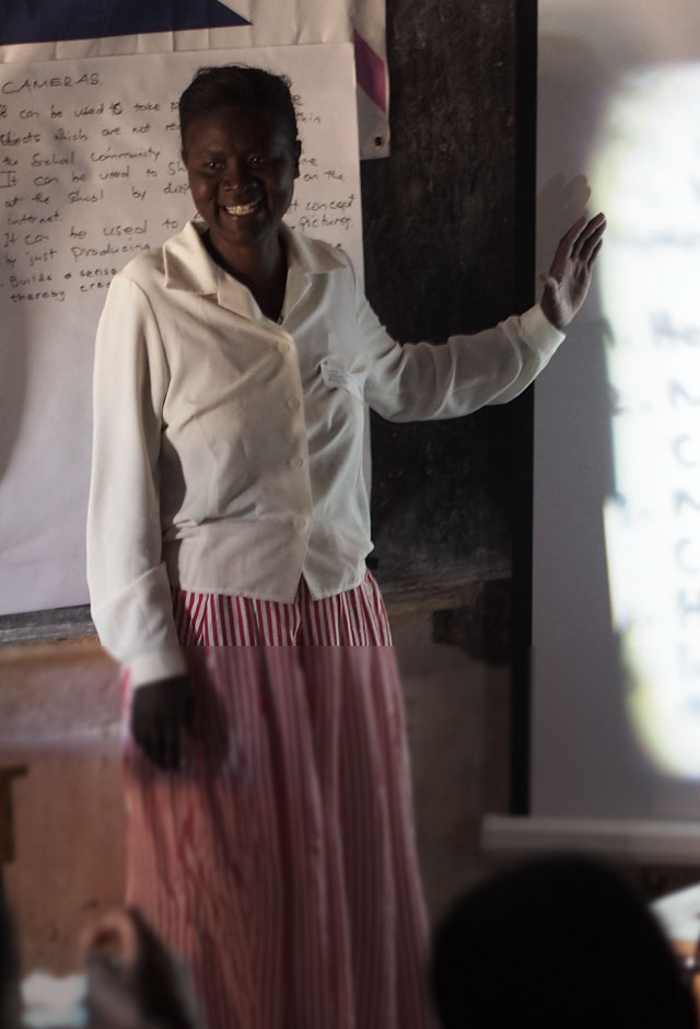 An image shows an African teacher giving a lecture