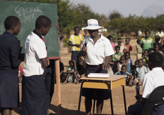 An image shows children acting out a skit