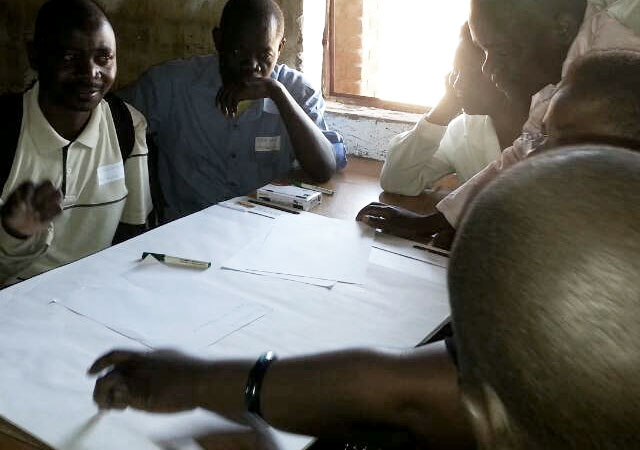 An image shows African teachers participating in a discussions