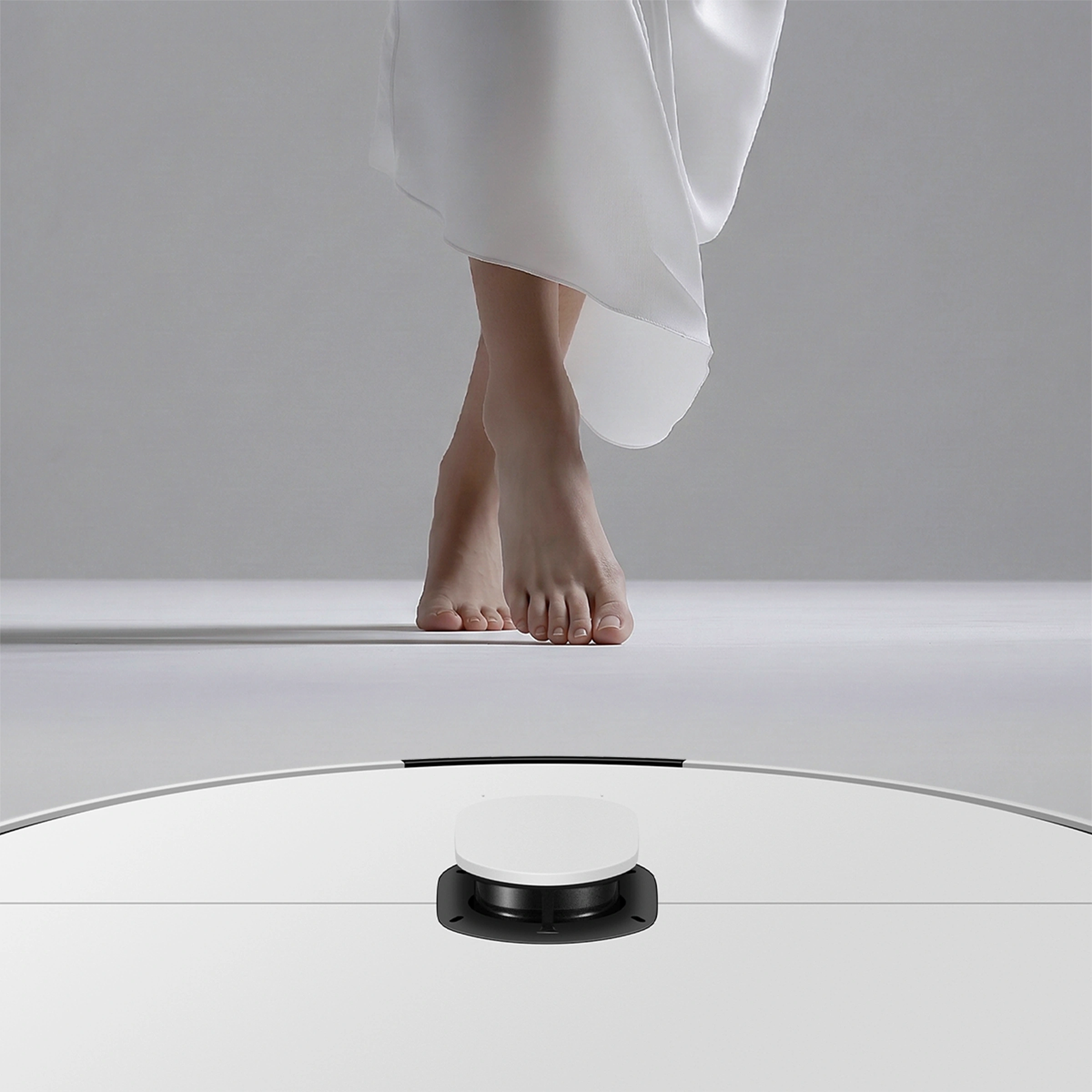 발끝으로 바닥을 딛는 인물과 하단 센서가 보이는 비스포크 에이아이 스팀 울트라.