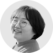 귀 밑까지 오는 짧은 머리와 안경을 착용하고 있는 여성