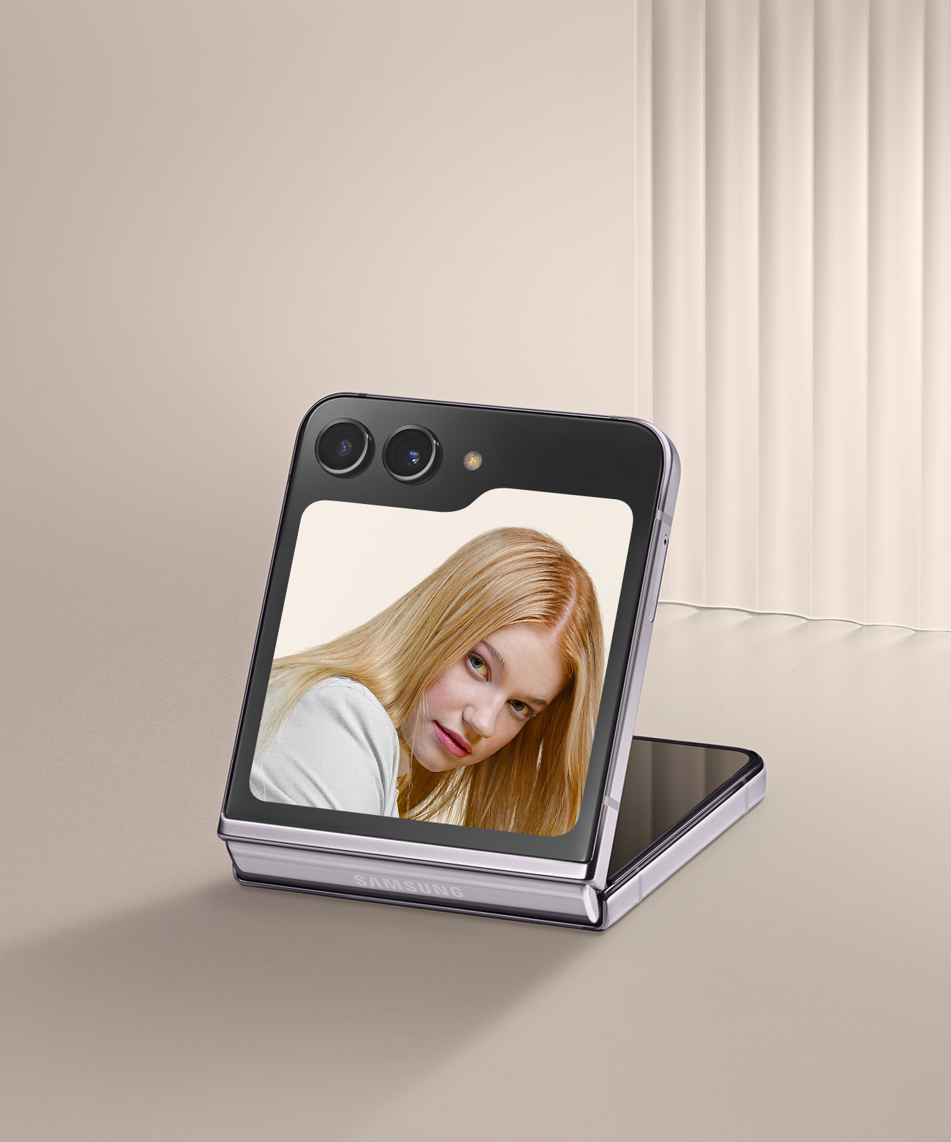 갤럭시 Z 플립5의 플렉스 윈도우로 스마트폰을 접은 상태에서 셀피를 촬영하는 이미지입니다.