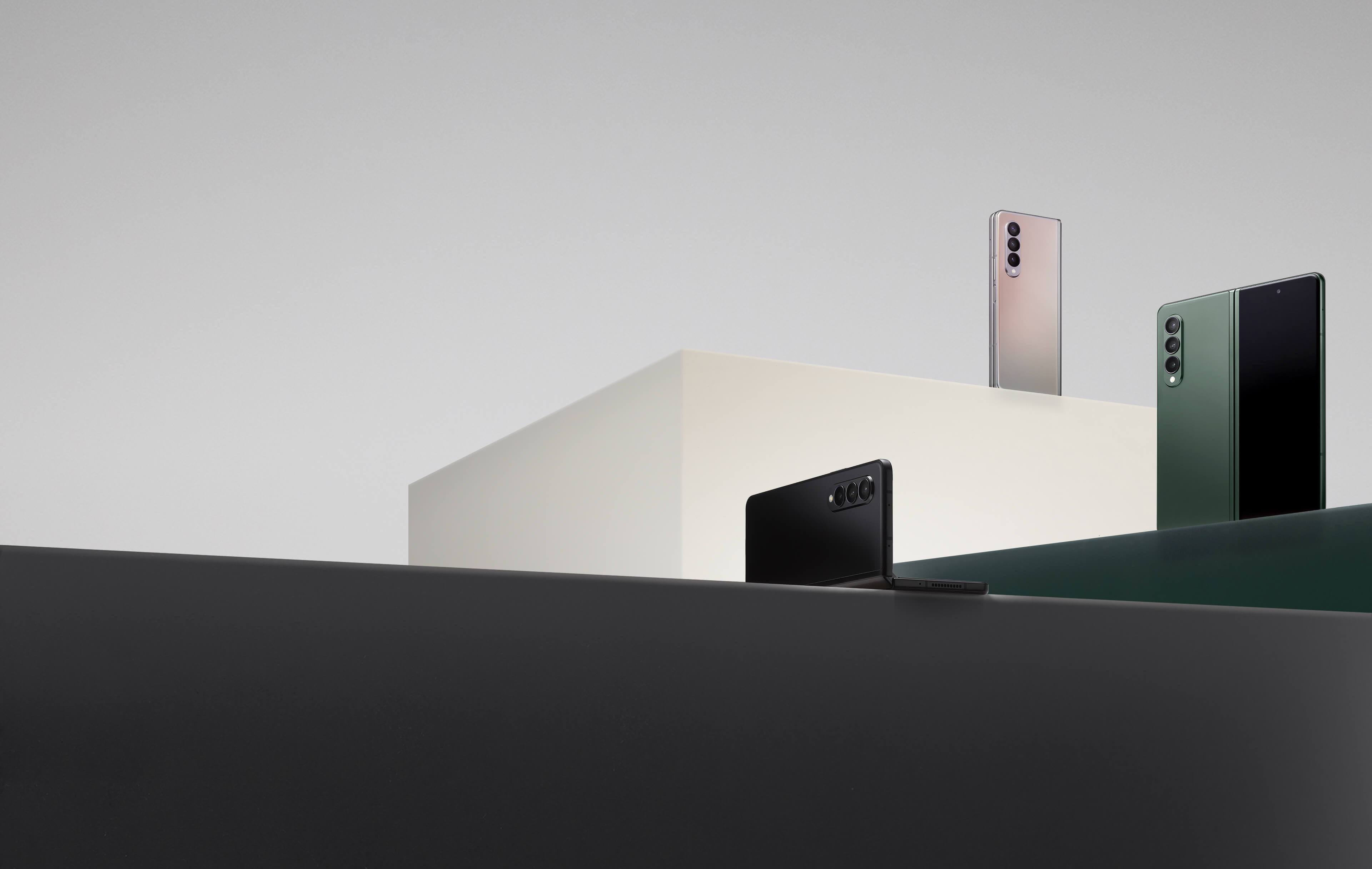 갤럭시 Z 폴드3의 팬텀 실버, 팬텀 블랙, 팬텀 그린 컬러 모델을 단상 위에 올려두고 찍은 사진입니다.