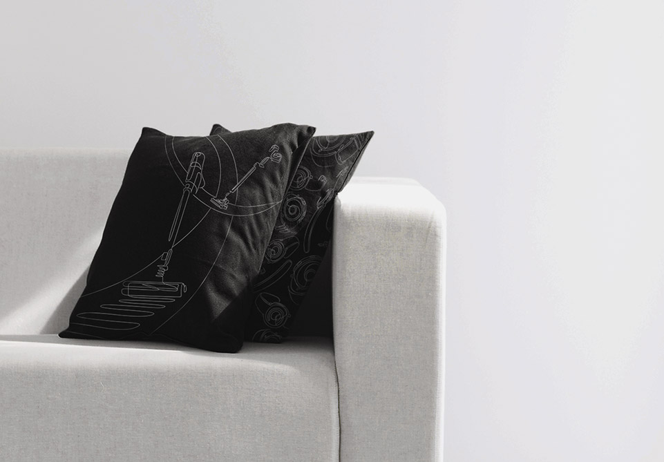 POWERGun 스틱청소기 일러스트가 그려진 검은색 쿠션 2개가 흰색 쇼파 위에 있는 이미지입니다.