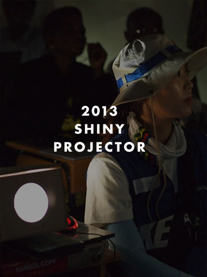 2013 Shiny Projector, 샤이니 프로젝터를 설치하고 화면을 보고 있는 사람들의 모습입니다. 마우스 오버하면 이미지가 밝아집니다.